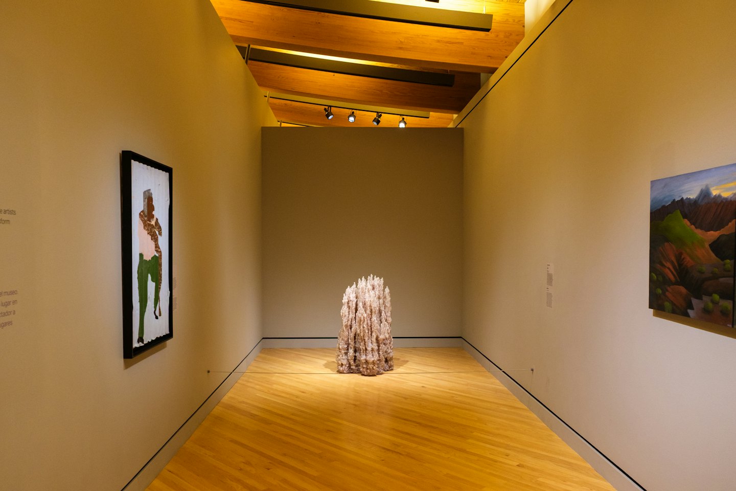 Corridoio di una galleria d'arte con dipinti astratti e paesaggistici.